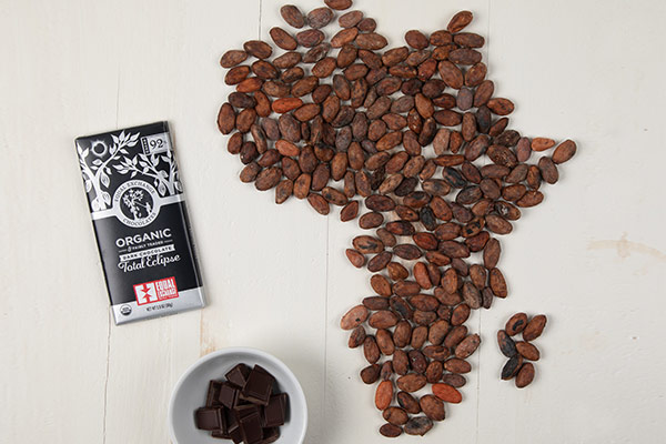 Chocolate bar next to coffee beans forming the shape of Africa