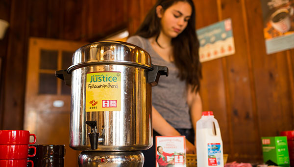 Young woman serving coffee from a percolator