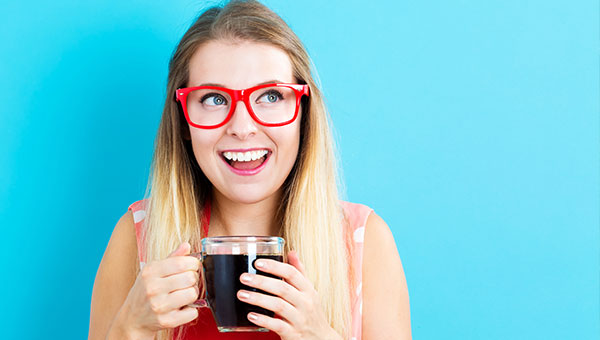 Young woman drinking coffee with a happy smile
